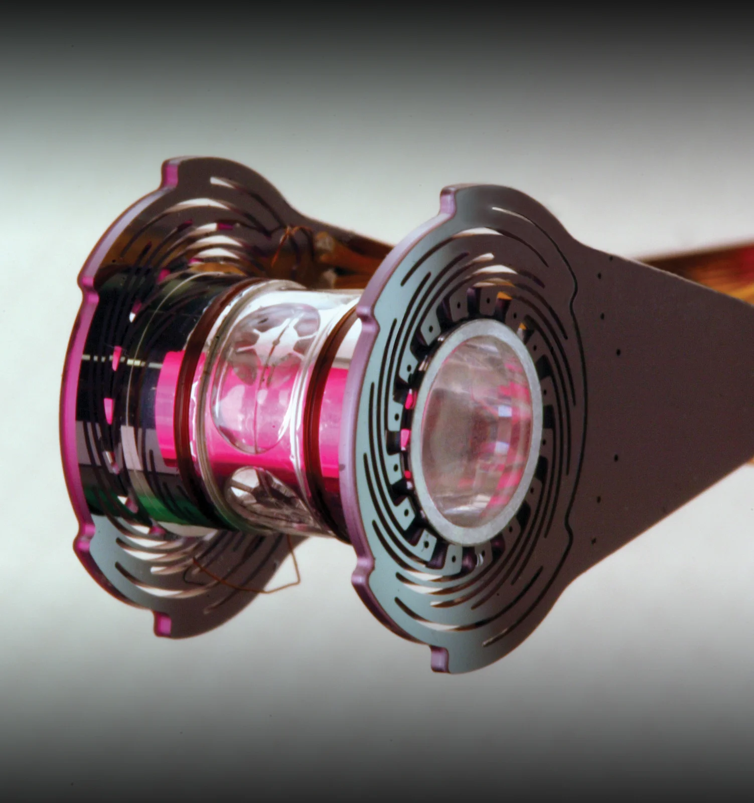A small assembled NIF target with a cylindrical hohlraum, capsule support and cooling structures on either side.